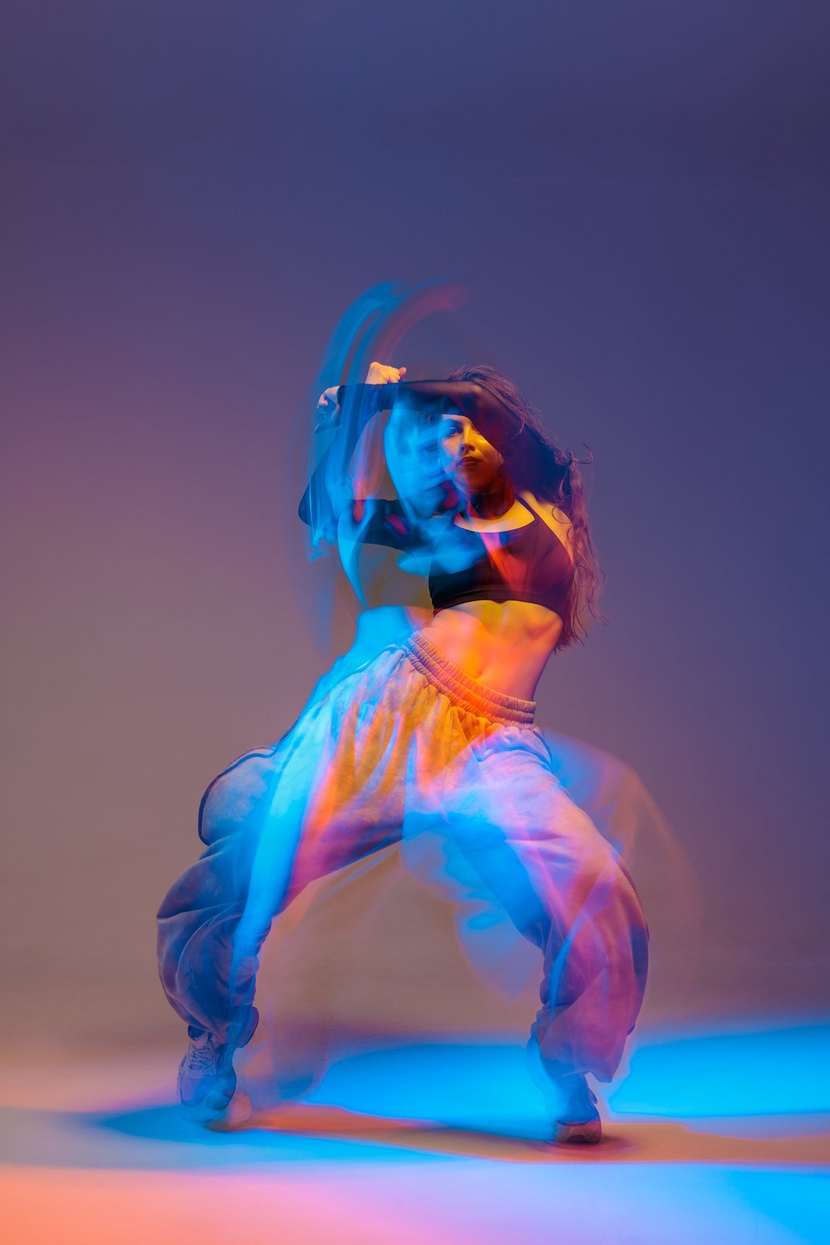 Energetic jazz dancer performing with artistic motion blur and vibrant neon colors